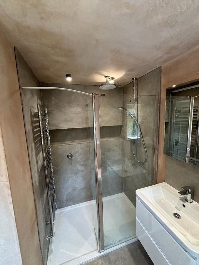 Micro-cement effect shower enclosure with chrome fittings during fit-out
