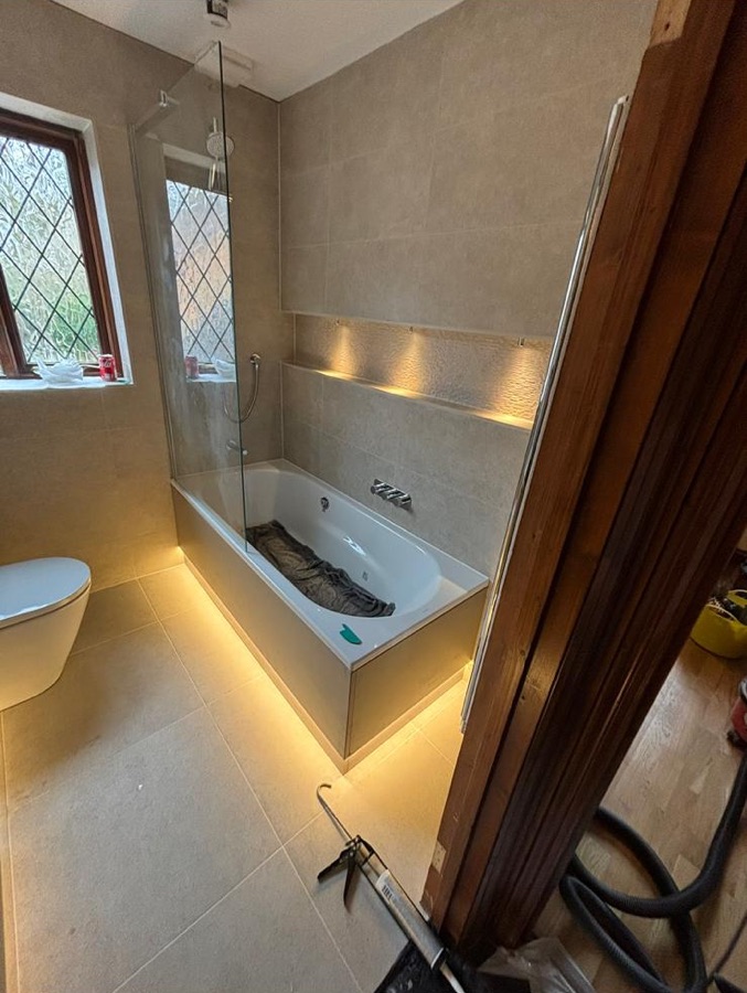 Fitted bath with LED lighting beneath and a lit recessed shelf, during fit-out