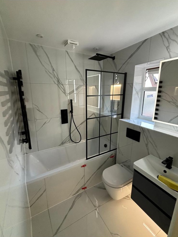 Marble-effect bathroom with black-framed shower screen and matt black shower